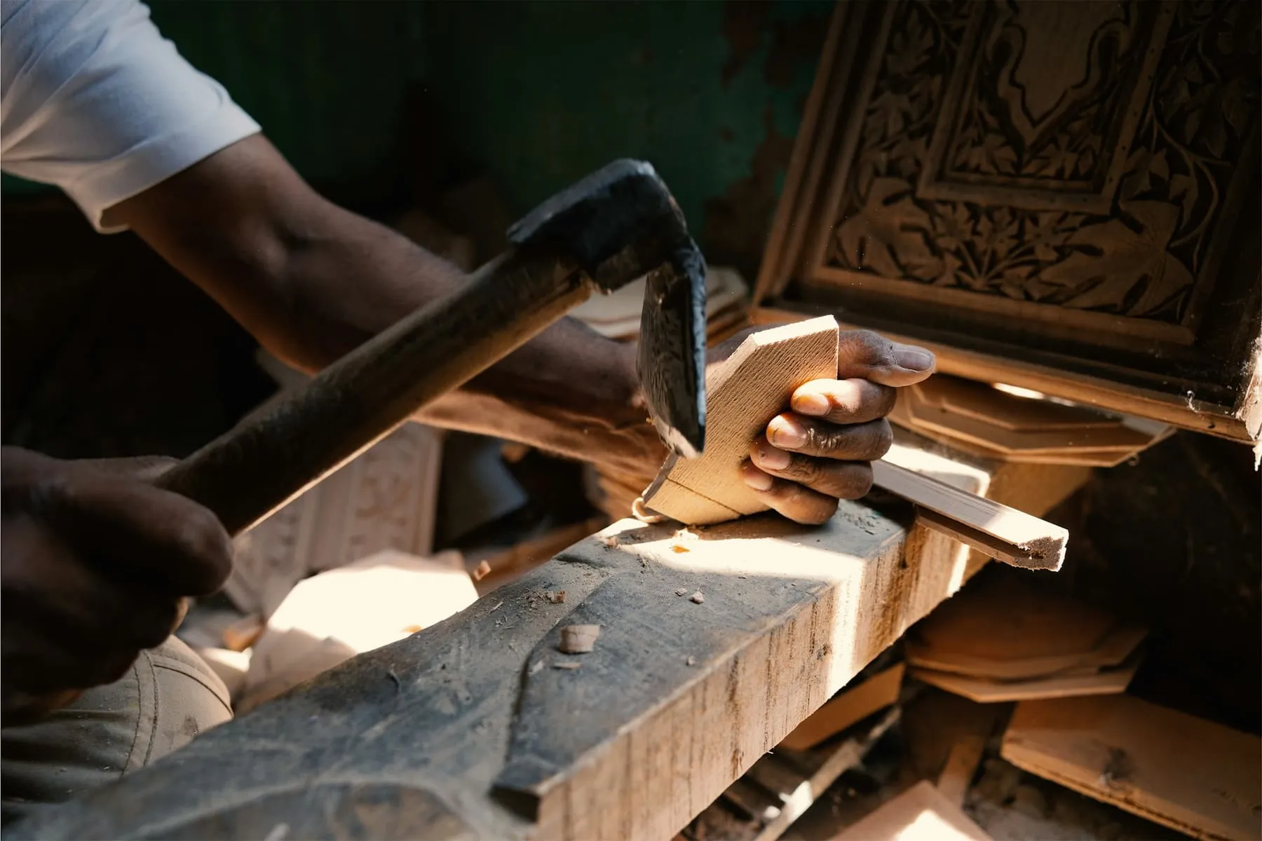 Artisan travaillant une pièce de bois au ciseau