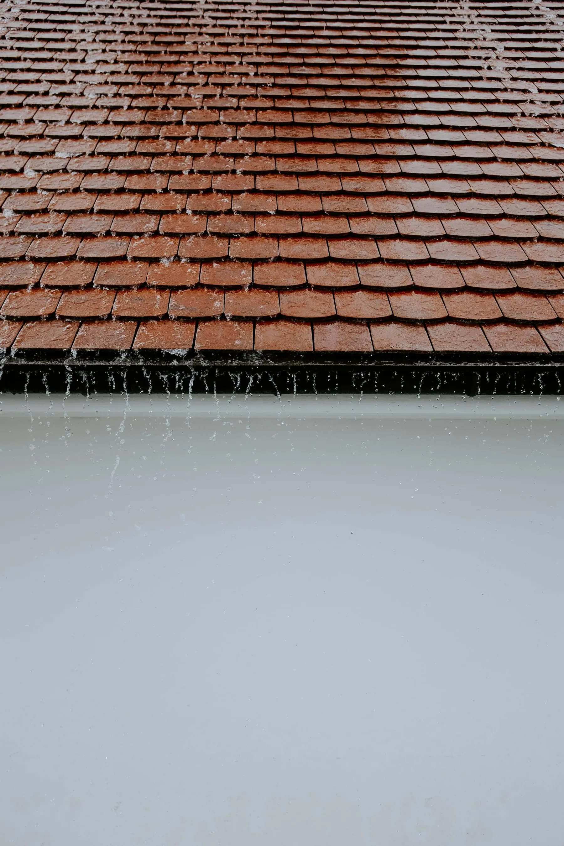 Pluie ruisselant depuis une toiture en tuiles
